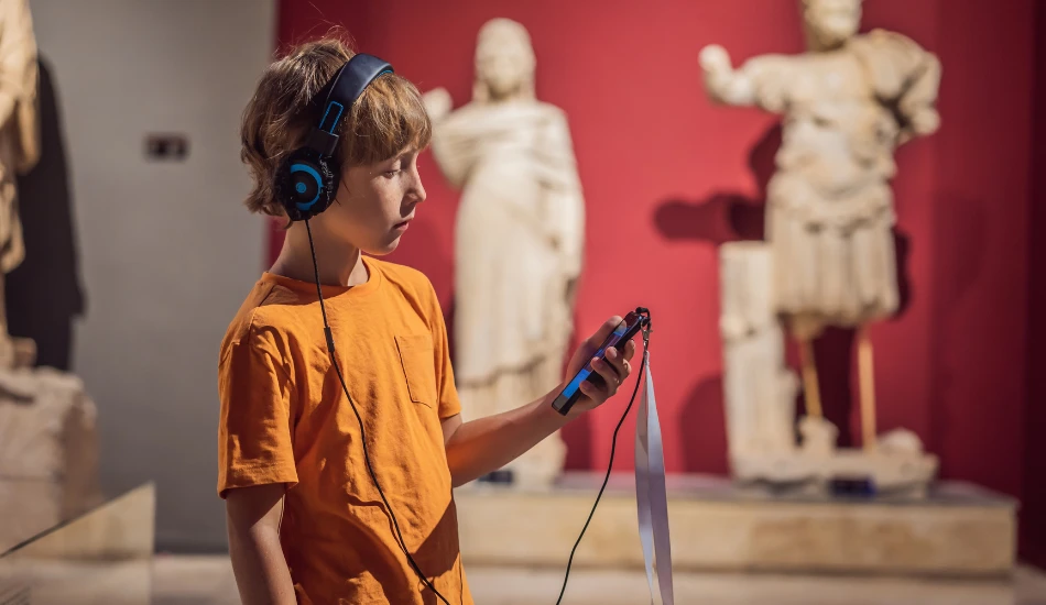 A young boy using audio guide for exploring attraction.